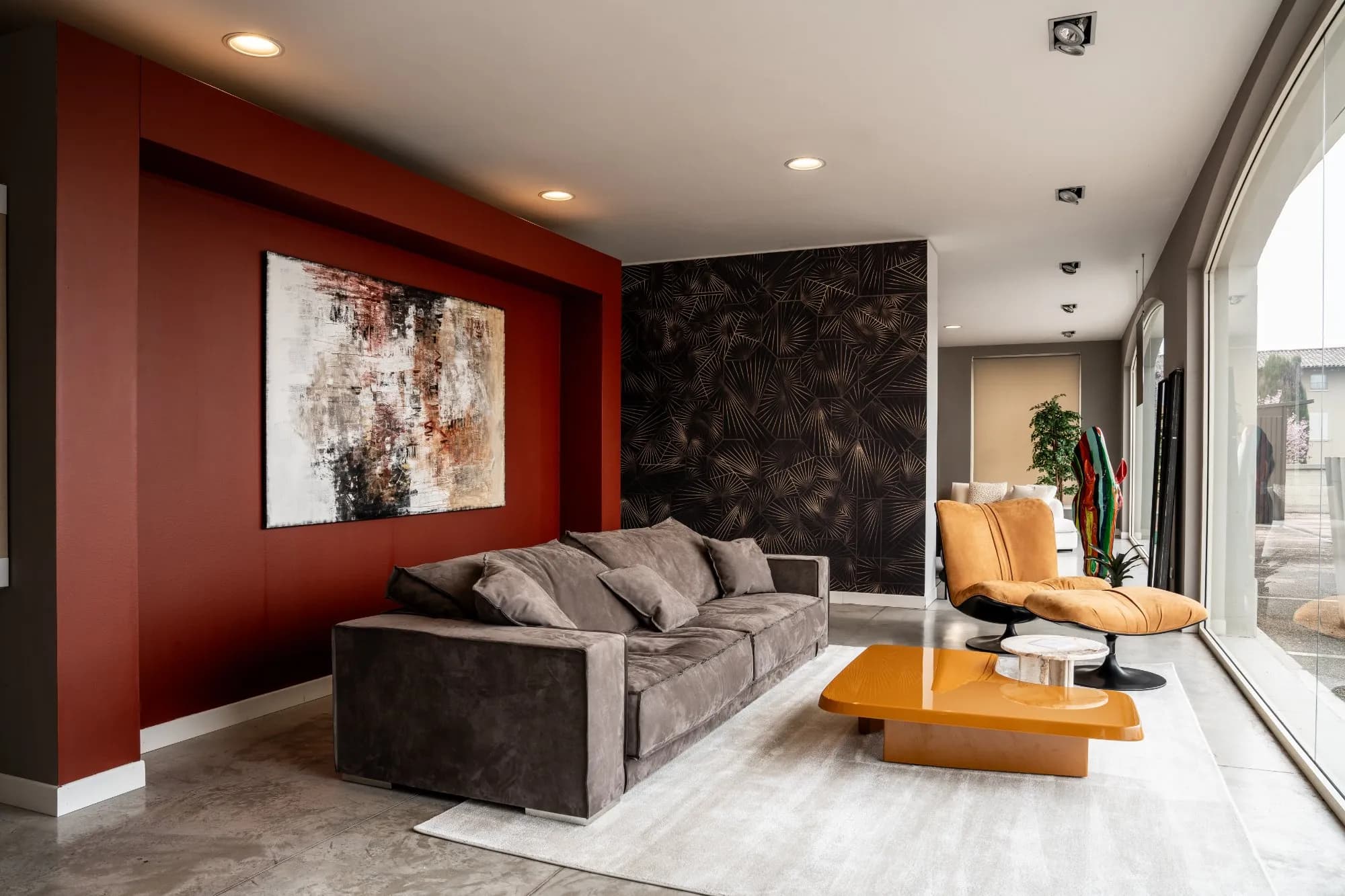 Living dello showroom, parete terracotta e superfici materiche